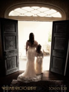 Bride and girl looking out doorway entrance